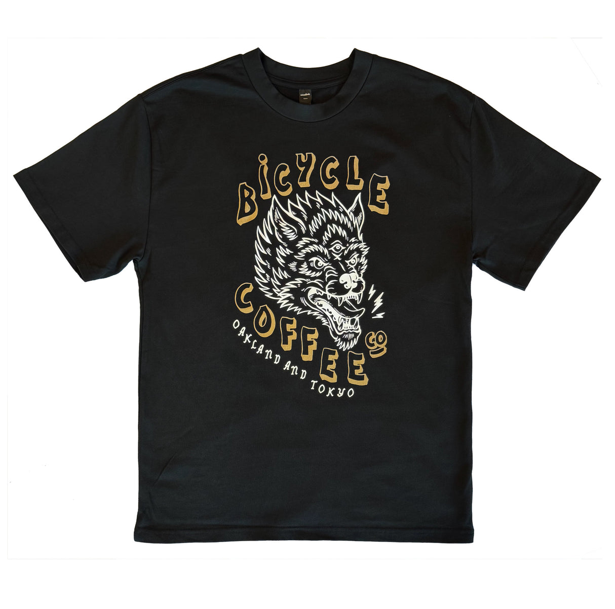 Black T-shirt featuring a white and gold graphic of a three-eyed wolf, with bold ‘Bicycle Coffee Co’ text and ‘Oakland and Tokyo’ printed below.