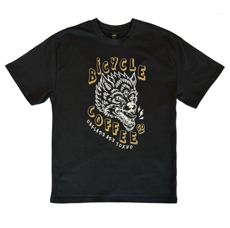 Black T-shirt featuring a white and gold graphic of a three-eyed wolf, with bold ‘Bicycle Coffee Co’ text and ‘Oakland and Tokyo’ printed below.