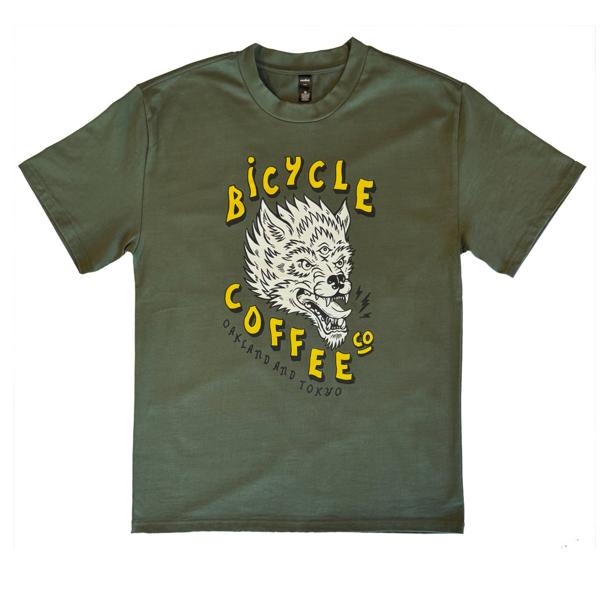 Olive green T-shirt featuring a bold graphic of a snarling three-eyed wolf, with yellow ‘Bicycle Coffee Co’ text and ‘Oakland and Tokyo’ printed below.
